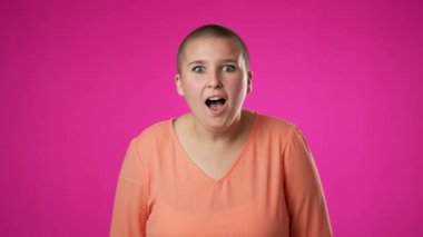 Şaşırmış genç cinsiyet değişiminin portresi. İkili kadın olmayan 20 'li yaşlarda büyük başarı kutlanıyor. Kazanan, EVET, WOW, pembe arka planda izole edilmiş..