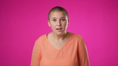 Şaşırmış genç cinsiyet değişiminin portresi. İkili kadın olmayan 20 'li yaşlarda büyük bir başarı kutluyor. Kazanan, AMAZING, pembe arka planda izole edilmiş bir şekilde baş parmağını kaldırıyor..