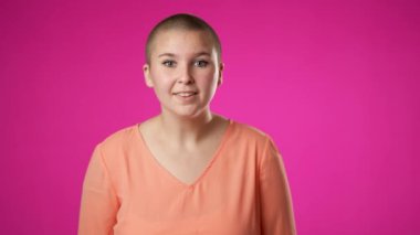 Mutlu cinsiyet değişiminin portresi. İkili olmayan, 20 'li yaşlarda, gülümseyen, el sallayan, elleri ağızda davetli genç bir kadın..