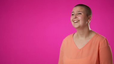 İkili cinsiyet değişmeyen 20 'li yaşlardaki genç kadının merkez dışı portresi harika anıları hatırlar, düşünür, pembe stüdyo portresi üzerinde izole edilmiş başparmaklar verir.