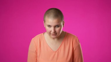 Öfkeli ümitsizlik, pembe arka planda izole edilmiş 20 'li yaşlarda, çift cinsiyetli olmayan güzel bir kadının yumruklanmış portresiyle altüst oldu. Yavaş çekim