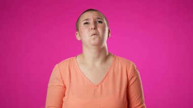 Kızgın, korkmuş, genç cinsiyet değişkeni, çift cinsiyetli olmayan 20 'li yaşlarda bir kadın ellerini başının üstüne koyup bağırıyor ve neden bana pembe arka plan stüdyosunda kapalı olduğumu soruyor. Yavaş çekim