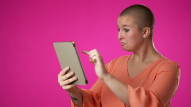Mutlu gülümseyen cinsiyet sıvısı portresi. İkili olmayan 20 'li yaşlardaki kadın. Mobil tablet bilgisayardan alışveriş yapıyor.