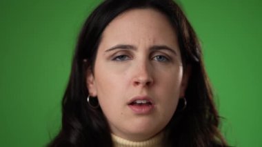 Yorgun, bitkin düşmüş baş ağrısı yorgun 20 'li yaşlardaki kadın yeşil ekran arka plan stüdyosunda yalnız poz veriyor. Yavaş çekim insan yaşam tarzı kavramını kapat.