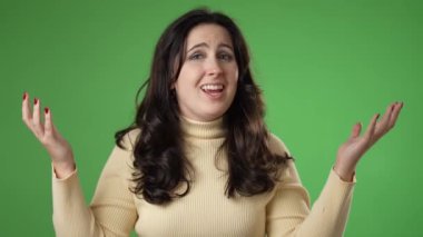 Kızgın, korkmuş 20 'li yaşlarda genç bir kadın ellerini başının üstüne koyup bağırıyor ve neden yeşil ekran arka plan stüdyosunda soyutlandığımı soruyor. Halk yaşam tarzı konsepti.