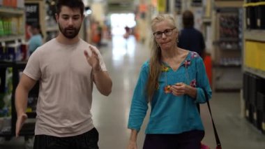 Mimar adam ve müşteri olgun kadın büyük bir kutu hırdavatçısında yürür..