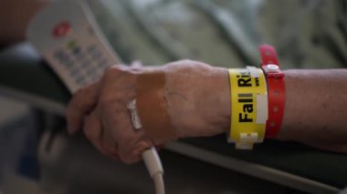 Sonbahar Riski bilekliğinin kapatılması yaşlı kadınların kol düğmesi elinde hastane yatağında duran acil çağrı düğmesi.. 