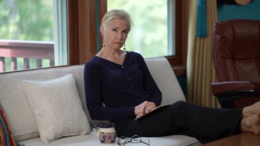 Esneyen, yorgun, bitkin, yaşlı, gri saçlı, 50 'li yaşlarda bir kadının portresi..