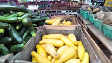 Canlı yeşil renklerini, pürüzsüz ciltlerini ve hafif kıvrımlı şekillerini sergileyen taze kabak sebzelerinin yakın plan görüntüsü. Sebzeler düzgünce istiflenmiş.