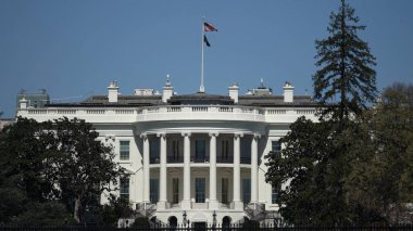 Ziyaretçiler, Washington DC 'de ilkbaharda yaşanan tarihi bina ve çevre yeşillikleri aydınlatan parlak güneş ışığıyla Beyaz Saray' a hayranlık duyuyorlar..