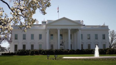 Washington 'daki Beyaz Saray' da bahar aylarında çiçek açan ve çeşme açan sergiler. Federal bina berrak bir gökyüzüne karşı dimdik dururken güneş parlıyor..