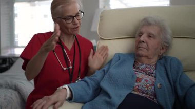 Bakıcı, yaşlı bir kadınla, öğleden sonra sağlık merkezinde destek ve arkadaşlık sağlayarak iletişim kurar..