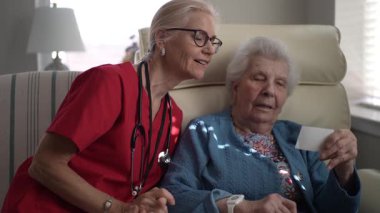 Bakıcı, yaşlı bir kadına rahat bir sağlık merkezinde hafıza görevinde yardımcı olur. Her ikisi de bir bağlantı ve bağlılık anını paylaşıyor.