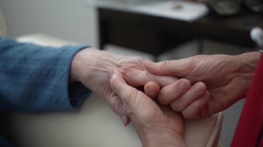 Bir çift el yakın planda gösteriliyor, rahatlamış bireylerin parmaklarına rahatlatıcı bir masaj yapıyor, seans boyunca bakım ve sükuneti vurguluyor..