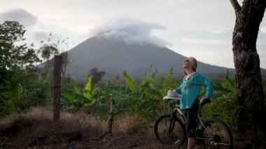Mutlu, olgun bir kadın, Ometepe Adası 'nın doğal güzelliğini kucaklıyor. Concepcion Volkanı yakınlarında bisiklet sürerken Orta Amerika' nın sakinliğini takdir ediyor..