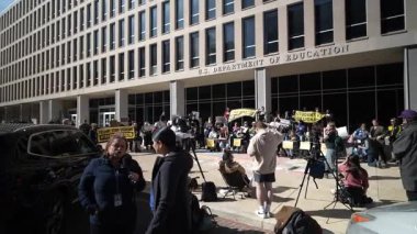 Washington, DC, ABD - 03 21 2025: İşlerinden yeni kovulan işçiler, sürmekte olan gösteriyi haber muhabirleri takip ederken ABD Eğitim Bakanlığı önünde eylem talep ediyorlar.