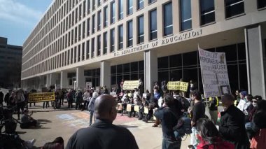 Washington, DC, ABD - 03 21 2025: İşlerinden yeni kovulan işçiler, sürmekte olan gösteriyi haber muhabirleri takip ederken ABD Eğitim Bakanlığı önünde eylem talep ediyorlar.