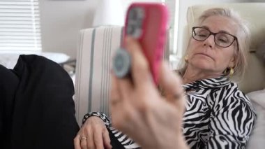 90 'lı yaşlarda yaşlı bir anne kızıyla görüntülü sohbetten zevk alır. Evde birlikte dinlenirken gülümseme ve kahkahaları paylaşır..