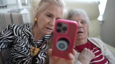 Bir kız çocuğu, rahatlamış ve dikkatle dinliyormuş gibi görünen yaşlı annesiyle görüntülü bir konuşma yapar. Yakın bağlarını ve bağlantılarını vurguluyor.