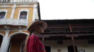 Olgun bir kadın, Granada, Nikaragua 'daki tarihi binaların canlı renklerinden ve karmaşık detaylarından zevk alır. Çevresindekileri görünce merakı belli oluyor..