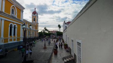 Turistler ve yerliler, coşkulu katedrali ve hareketli atmosferiyle Granada, Nikaragua 'da Calzada' da geziyorlar..