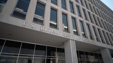 ABD Eğitim Bakanlığı binası Washington D.C. 'de gün ortasında modern mimari ve açık mavi gökyüzünü gözler önüne seriyor..