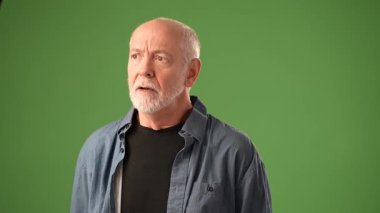 Sakallı, olgun bir adam, elleri sağlam yeşil bir perdeye yaslıyken neden yoğun duygularla hareket ettiğimi soruyor. Ayarlar onun ifadesini açıkça vurguluyor..