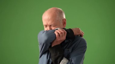 Olgun bir adam başını tutup baş ağrısını dindirmeye çalışır. Bir fotoğraf çekimi sırasında yeşil bir zeminin önünde dikilirken derin duygular taşır..