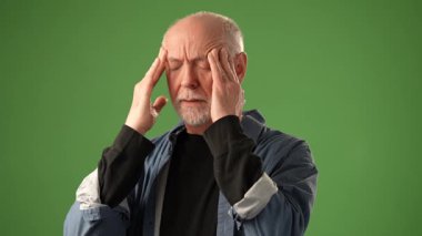 Düşünceli bir ifadeye sahip olgun bir adam, katı yeşil bir ekranın önünde bir mektup tutuyor. İçindekilerle ilgilenirken çeşitli duygular gösteriyor..