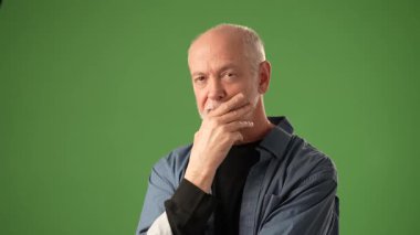 Hüzünlü bir ifadeye sahip son sınıf öğrencisi, yeşil bir ekranın önünde durmuş, bir amaç ve düşünce duygusu gösteren kötü bir haber mektubu tutuyor..