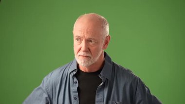 Düşünceli ve sıkıcı bir ifadeye sahip olgun bir adam katı yeşil perde arkasında duruyor. Elleri birbirine kenetlenmiş, derin düşüncelere ya da yansımaya işaret ediyor..