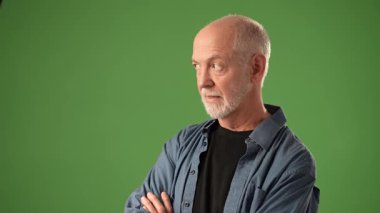 Olgun bir adam düşünceli bir duruşta yakalanır. Duygularını açık yeşil bir perdeye yansıtır. Yüzündeki ifadeye ve davranışlarına odaklanmış durumda..