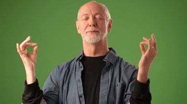 Son sınıf öğrencisi, yeşil bir perde arkasında ellerini izole bir şekilde gözlerini ovuşturmaktan yoruldu. Yüzündeki ifade bir anlık yansımayı ya da üzüntüyü yakalıyor..