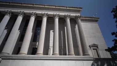Ulusal Arşiv binasının uzun kolonları Washington DC 'de açık mavi gökyüzüne karşı görkemli bir şekilde duruyor..