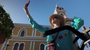 Olgun bir kadın Nikaragua, Granada Katedrali 'nin önünde keyifle poz veriyor. Bisikletiyle Orta Amerika' daki canlı turizm deneyimini sergiliyor..