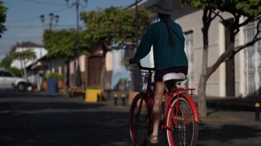 Olgun bir kadın, Orta Amerika 'nın zengin kültürünü deneyimleyerek Granada, Nikaragua' nın büyüleyici sokaklarında bisiklet sürmekten keyif alır..