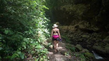 Olgun bir kadın, Nikaragua 'daki San Ramon şelalesine doğru yemyeşil bir alanda dar bir patika boyunca yürüyor. Macera Orta Amerika 'daki Ometeor Adası' nın güzelliğini gözler önüne seriyor..