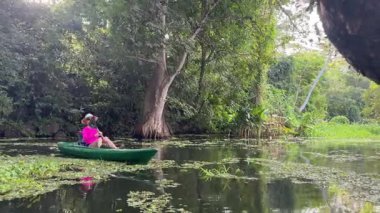 Olgun bir kadın Nikaragua Gölü 'nde mutlu bir şekilde kano kullanıyor. Etrafı yemyeşil yemyeşil ve Orta Amerika, Granada' da eğlenceli bir doğa deneyimi yaşıyor..
