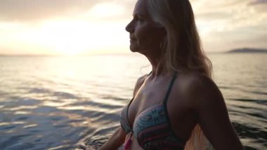 Mutlu, çekici, olgun bir kadın Nikaragua Gölü 'nün kenarında duruyor, silueti güzel bir günbatımına karşı, arkasında Concepcion volkanı ile.