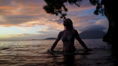 Concepcion, Nikaragua 'da mutlu bir orta yaşlı kadın günbatımının güzelliğini ve Concepcion Volkanı' nın manzarasını kucaklıyor..