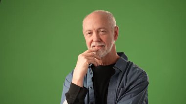 Olgun bir adam, katı yeşil bir ekranın önünde duruyor. Dostça bir jest sergiliyor. Duygularını aktarırken buraya gel diyor. Yaratıcı projeler ya da hikaye anlatımı için ideal.