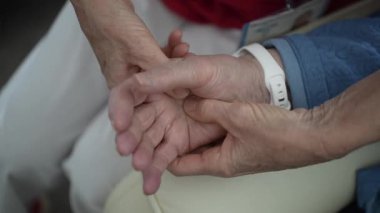 Bir bakıcı, destek ve etkileşime odaklanmış bir süre boyunca bir sağlık merkezinde bağlanma ve rahatlığı teşvik eden yaşlı bir kadının elini tutar..