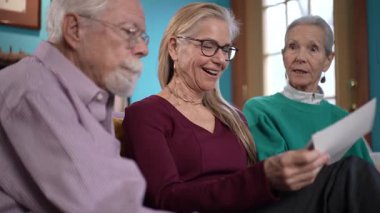 İki yaşlı ebeveyn, yetişkin çocuklarının sevgi ve sevgi dolu anılarla dolu sıcak bir oturma odasında anılarını tazeleyip paylaştıkları samimi bir anın tadını çıkarıyorlar..