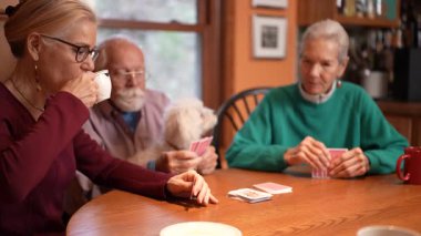 Üç yetişkin, bir masanın etrafında toplanır, iskambil oynarlar ve sıcak bir anı paylaşırlar. Bu arada kahve ve arkadaşlığın tadını çıkarırlar..