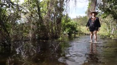 Gülümseyen olgun bir kadın Ometepe Adası 'ndaki Charco Verde' nin yemyeşil ormanını keşfediyor. Huzurlu sular etrafındaki canlı yeşilliği yansıtıyor..