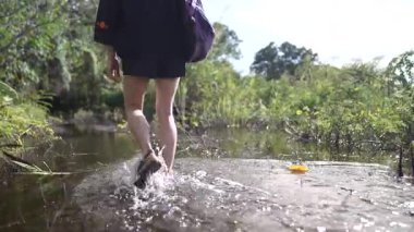Olgun bir kadın, Nikaragua 'daki Ometepe Adası' ndaki yemyeşil yemyeşil Charco Verde 'nin sığ sularında yürüyor ve Orta Amerika' daki doğanın güzelliğini kucaklıyor..