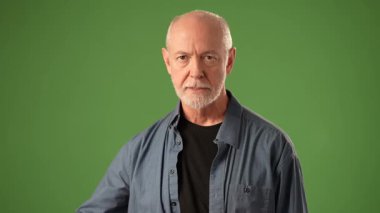 Olgun bir adam elleriyle kalp şeklini oluştururken sıcak bir şekilde gülümser. Dost canlısı bir tavır sergiliyor..