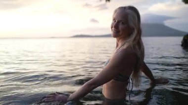 Mutlu, çekici bir kadın Concepcion Gölü 'nün sakin sularında volkan arka planda belirdiğinde sakin günbatımının tadını çıkararak yürüyor..