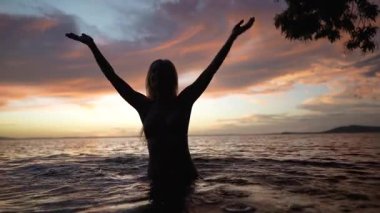 Mutlu, olgun bir kadın Concepcion yanardağının yanındaki göle doğru yürüyor. Kollarıyla su sıçratırken huzurlu bir günbatımının tadını çıkarıyor..