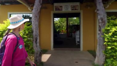 Olgun bir kadın Moyogalpa, Ometepe Adası ve Nikaragua 'nın hareketli sokaklarında geziniyor. Yeşillik, Orta Amerika 'da güneşli bir günde renkli evleri çevrelemektedir..